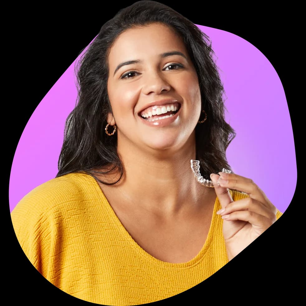 Woman with yellow shirt holding aligners