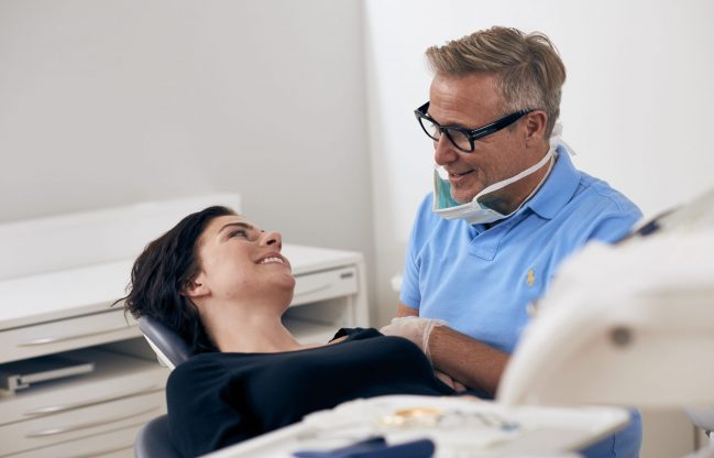 Smiling dentist with patient