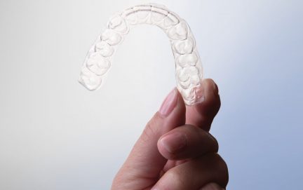 hand holding up clear aligners