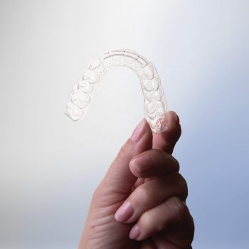 hand holding up clear aligners